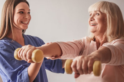caregiver and old woman doing exercise
