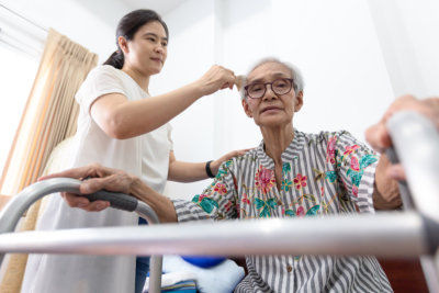 caregiver helps the old woman in the wheel chair